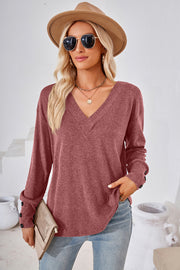 Rust V-neck top with button cuffs and a slouchy fit.