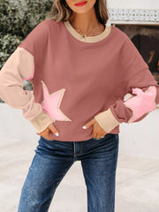 Dusty pink sweatshirt with contrast star patchwork and exposed seams.