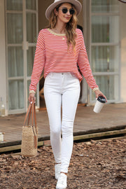 Red and white striped crewneck sweater with contrast trim, long sleeves, and a relaxed fit.