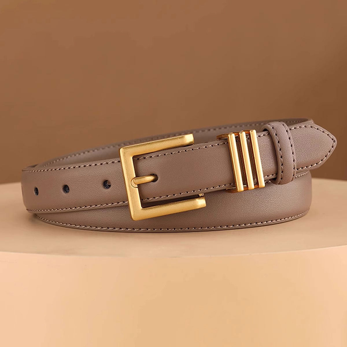Khaki cowhide leather belt with adjustable gold buckle and triple bar detail.