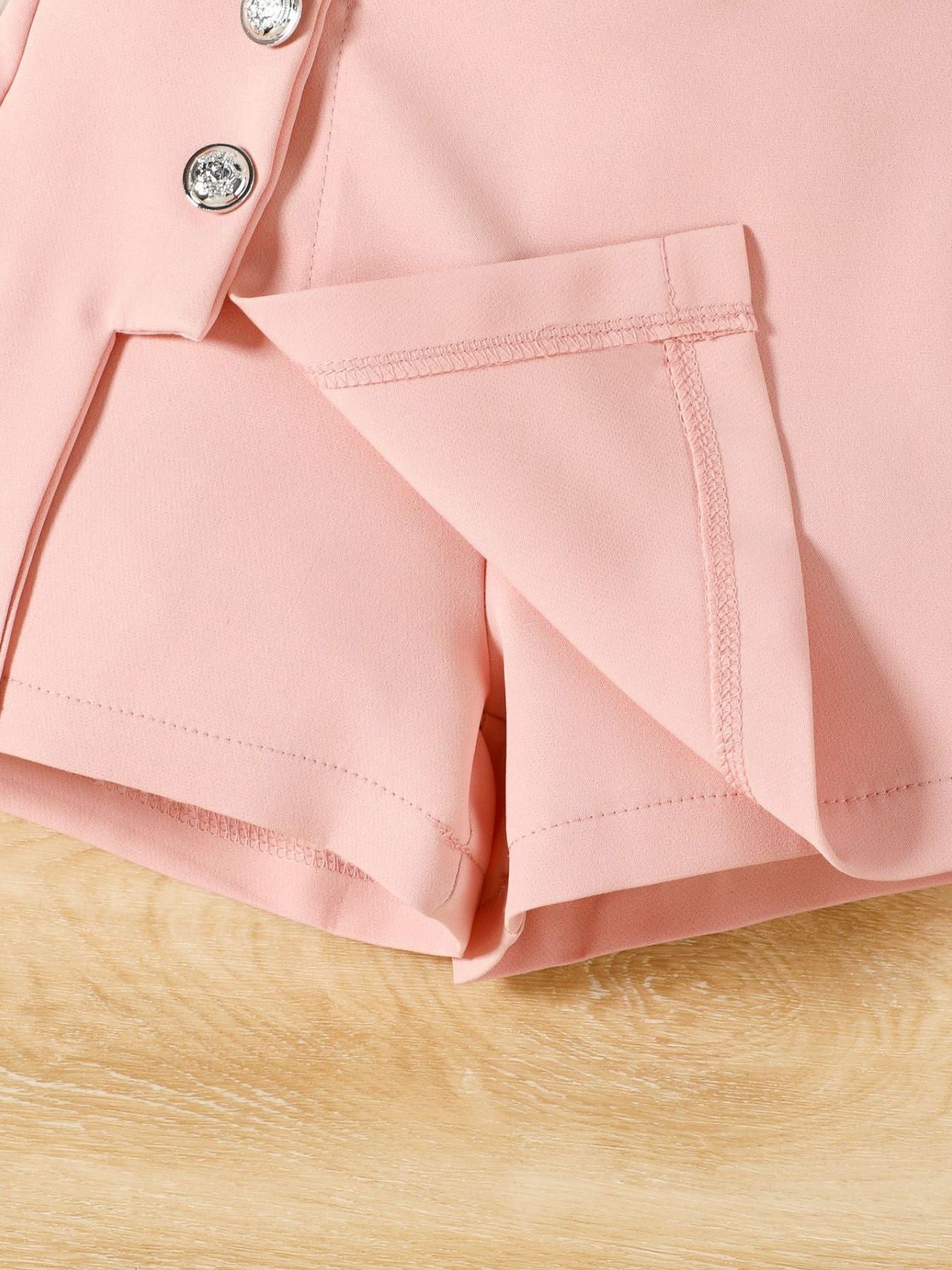 Pink toddler shorts with decorative buttons and a-line cut