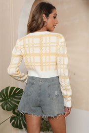 Plaid crop cardigan in white and gold with puff shoulders and button detail.