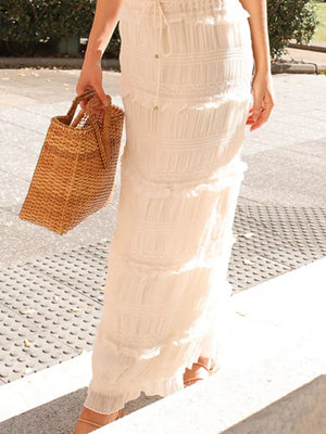 Cream halter neck smocked two-piece ensemble with tiered ruffles and drawstring waist.