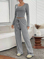 Black striped loungewear set with long sleeve crop top and drawstring pants.