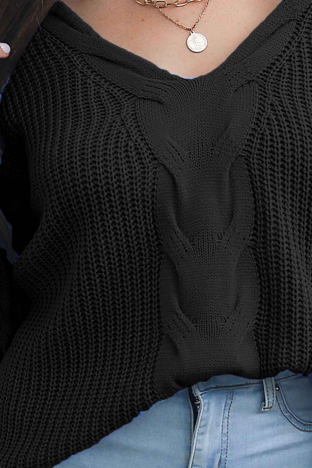 Black cable knit V-neck pullover sweater with textured knit detail.