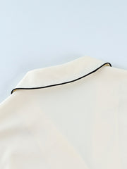 Cream button-up lounge set with black piping detail on collar