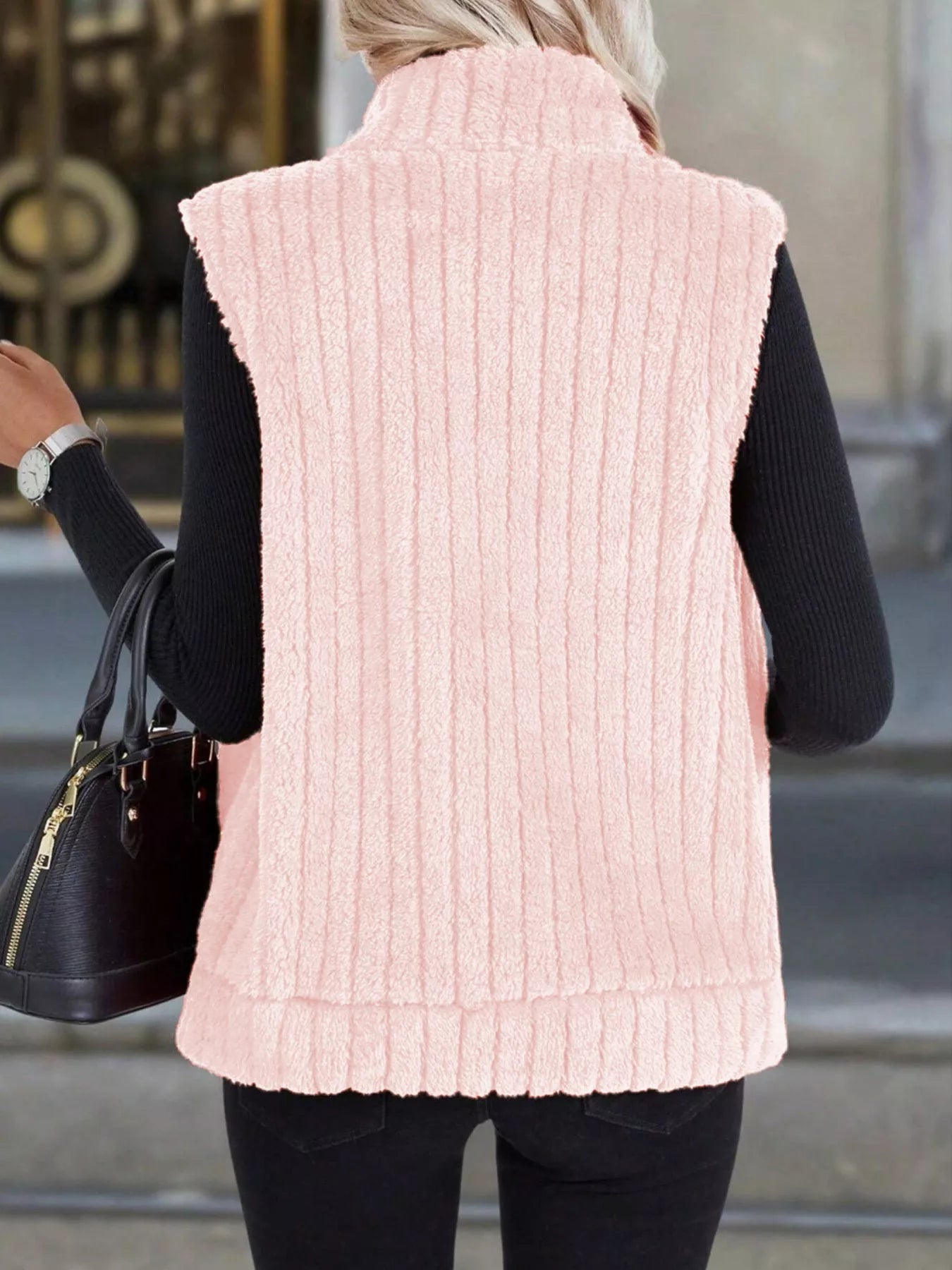 Pink fleece zip-up vest with vertical ribbing and a stand-up collar.