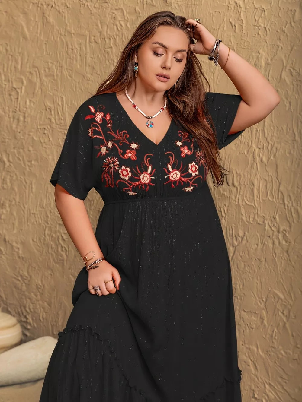 Black plus size maxi dress with V-neck and embroidered floral detail, short sleeves, tiered hem.