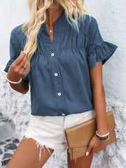 Dusty blue button-up blouse with gathered yoke and ruffle sleeves.