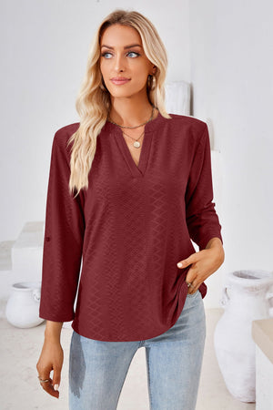 Burgundy textured henley blouse with rolled sleeves and a v-neck.