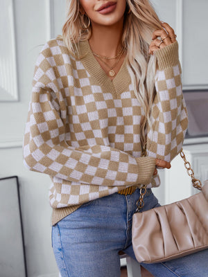 Checkerboard knit v-neck pullover sweater in camel and white, with long sleeves and a relaxed fit.