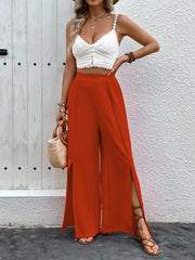 Orange-red textured palazzo trousers with dramatic side slits and a wide leg.