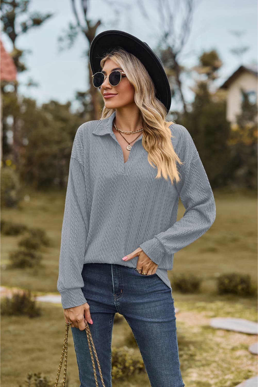 Textured cable knit polo top in light blue with a V-neck and long sleeves.