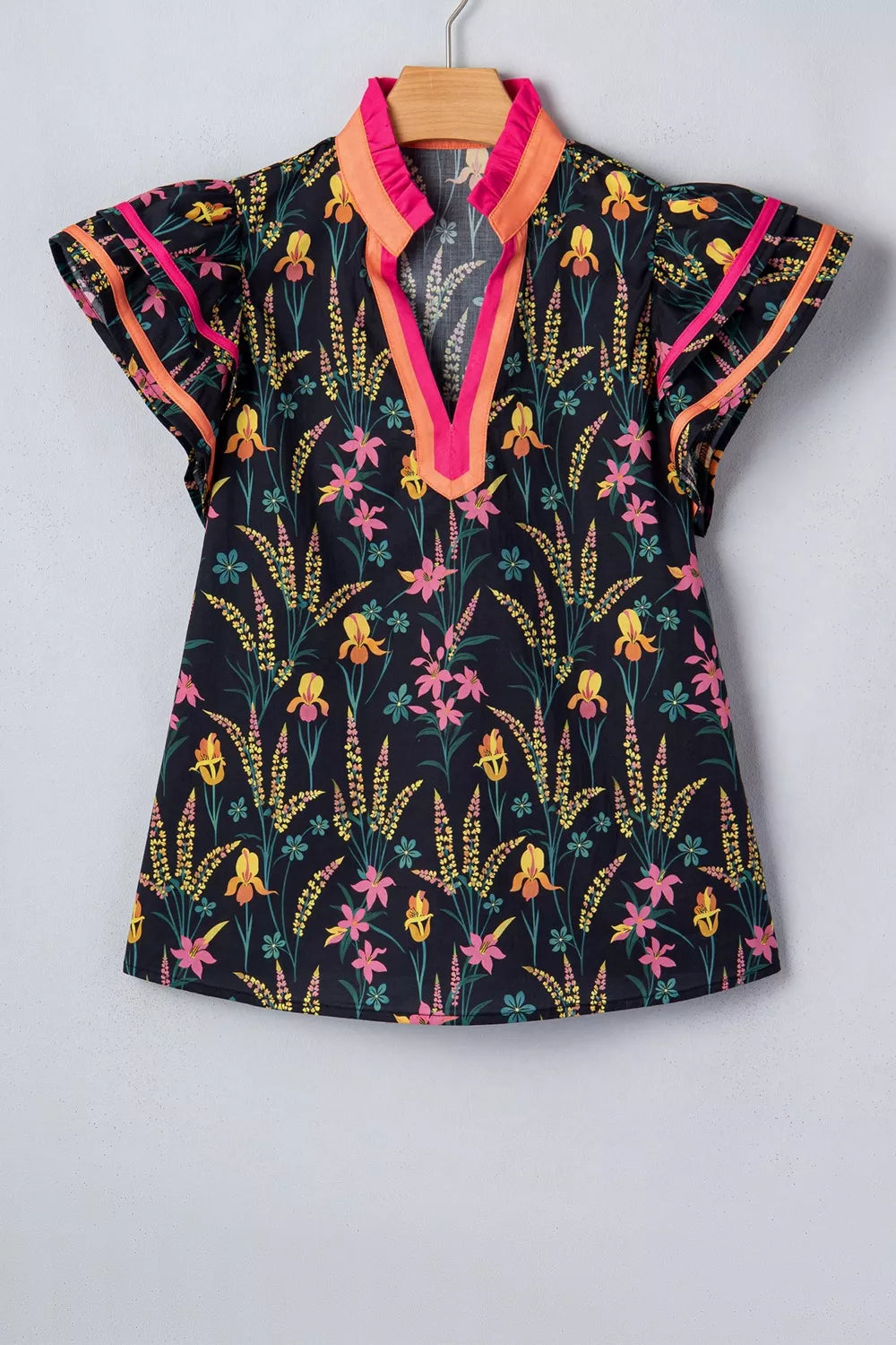 Vibrant floral print cotton blouse with contrast trim neckline and flutter sleeves.