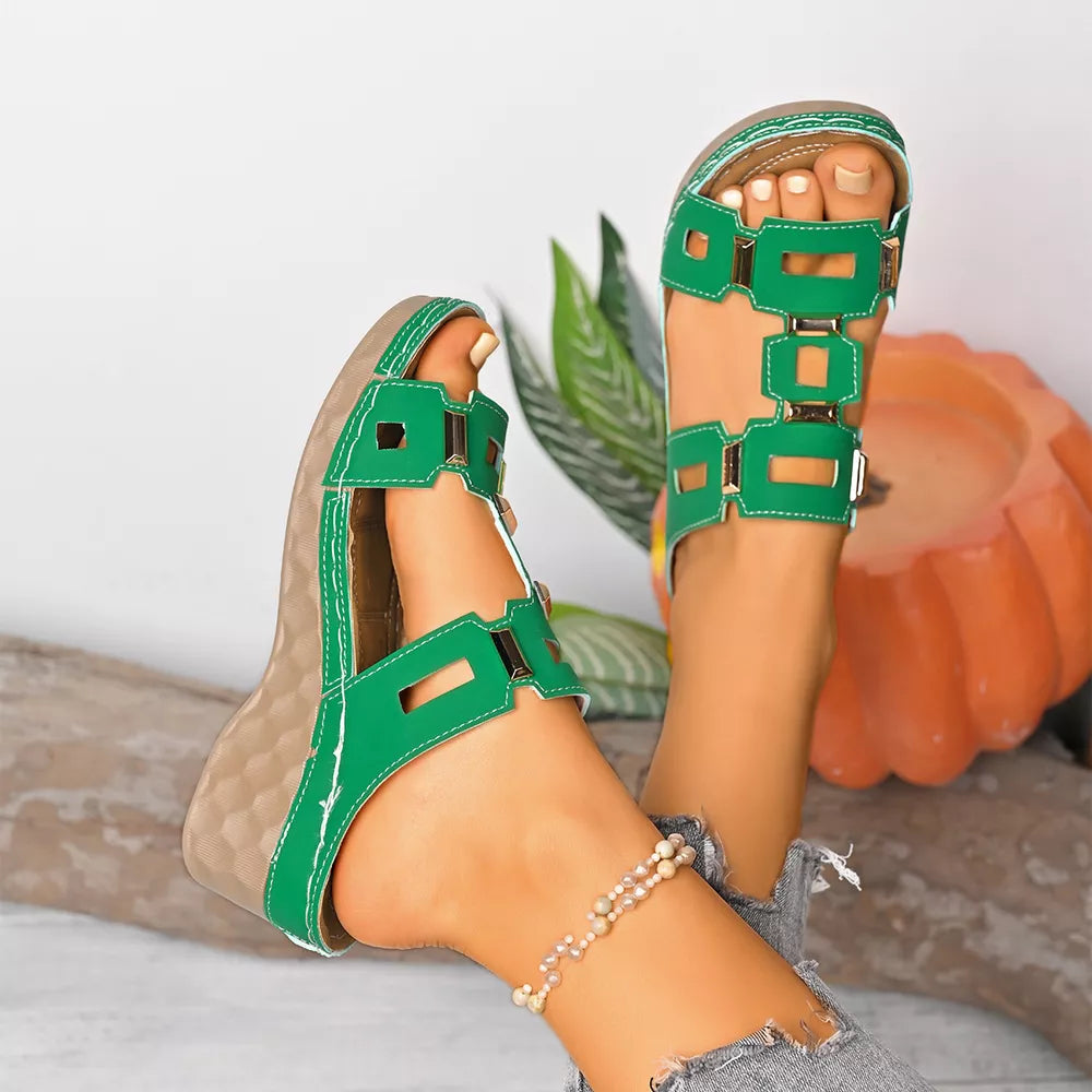 Green open-toe wedge sandals with cutout straps and buckle detail.
