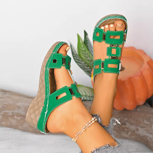 Green open-toe wedge sandals with cutout straps and buckle detail.
