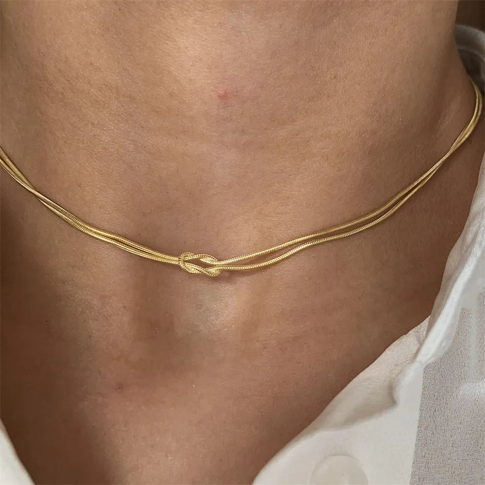 Gold serpent knot necklace with double chain detail