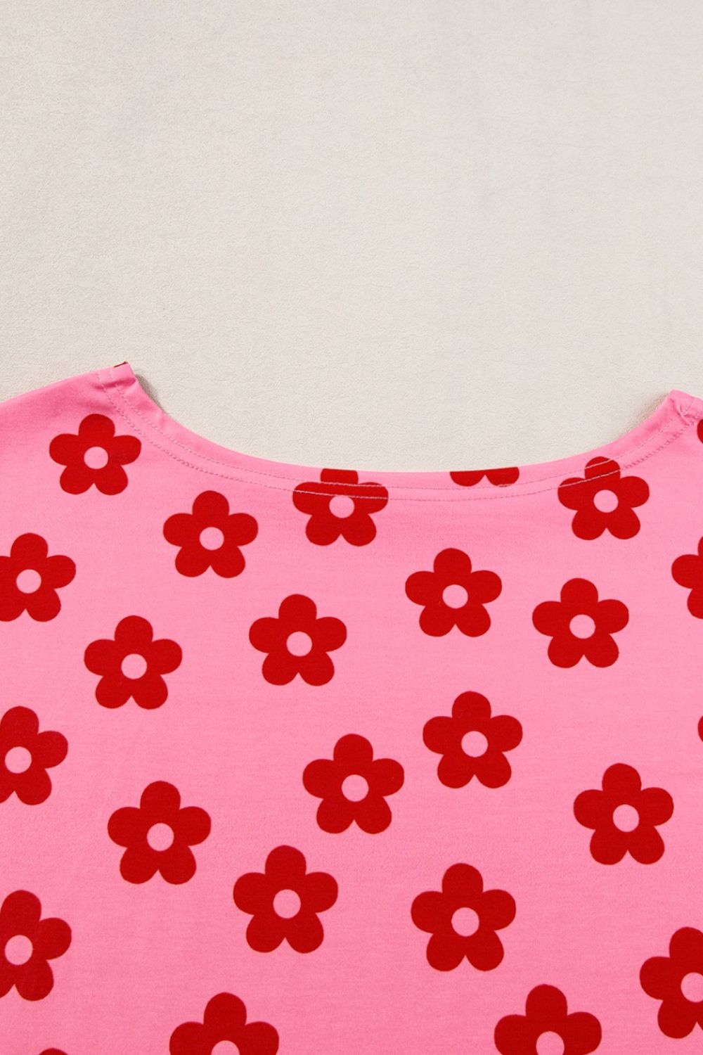 Coral pink crop top with red retro floral print and crew neck.