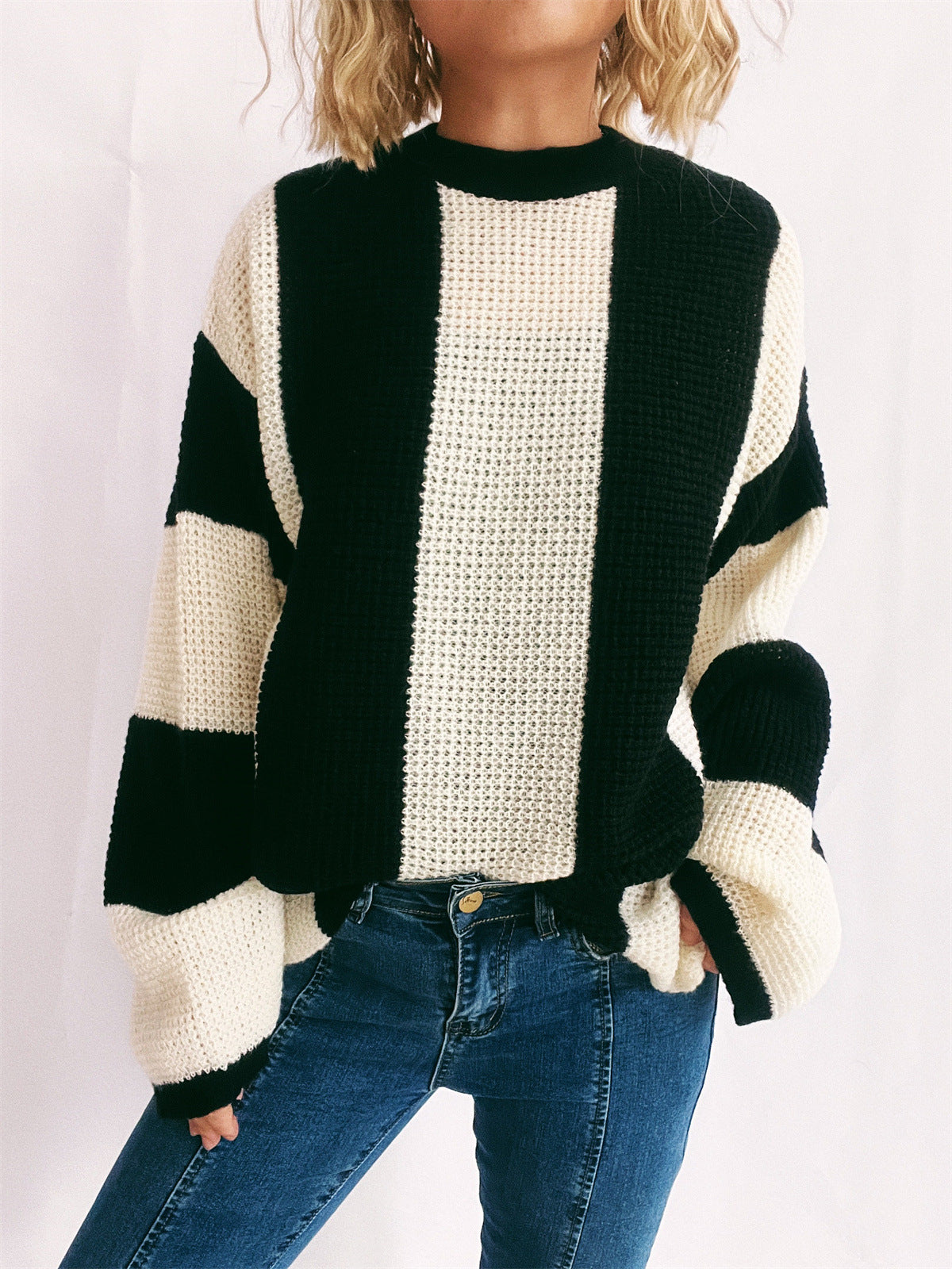 Black and cream vertical stripe waffle knit sweater with crew neck and long sleeves.