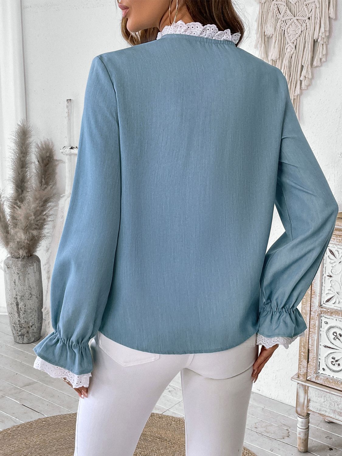 Light blue long sleeve blouse with lace trim at the neckline and cuffs.