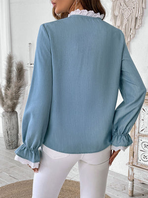 Light blue long sleeve blouse with lace trim at the neckline and cuffs.