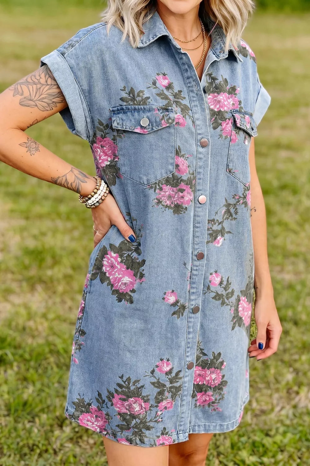 Denim shirt dress with pink floral print, short sleeves, collared neckline, and button front.