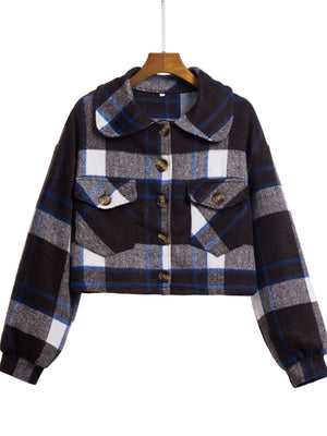 Chic plaid jacket in dark blue, white, and gray with buttoned chest pockets and a collared neckline.