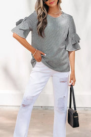 Gingham ruffled sleeve shirt in black and white polyester, styled with white ripped jeans.