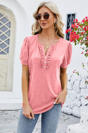 Watermelon pink tee with ruffled placket, button detail, and puff sleeves.