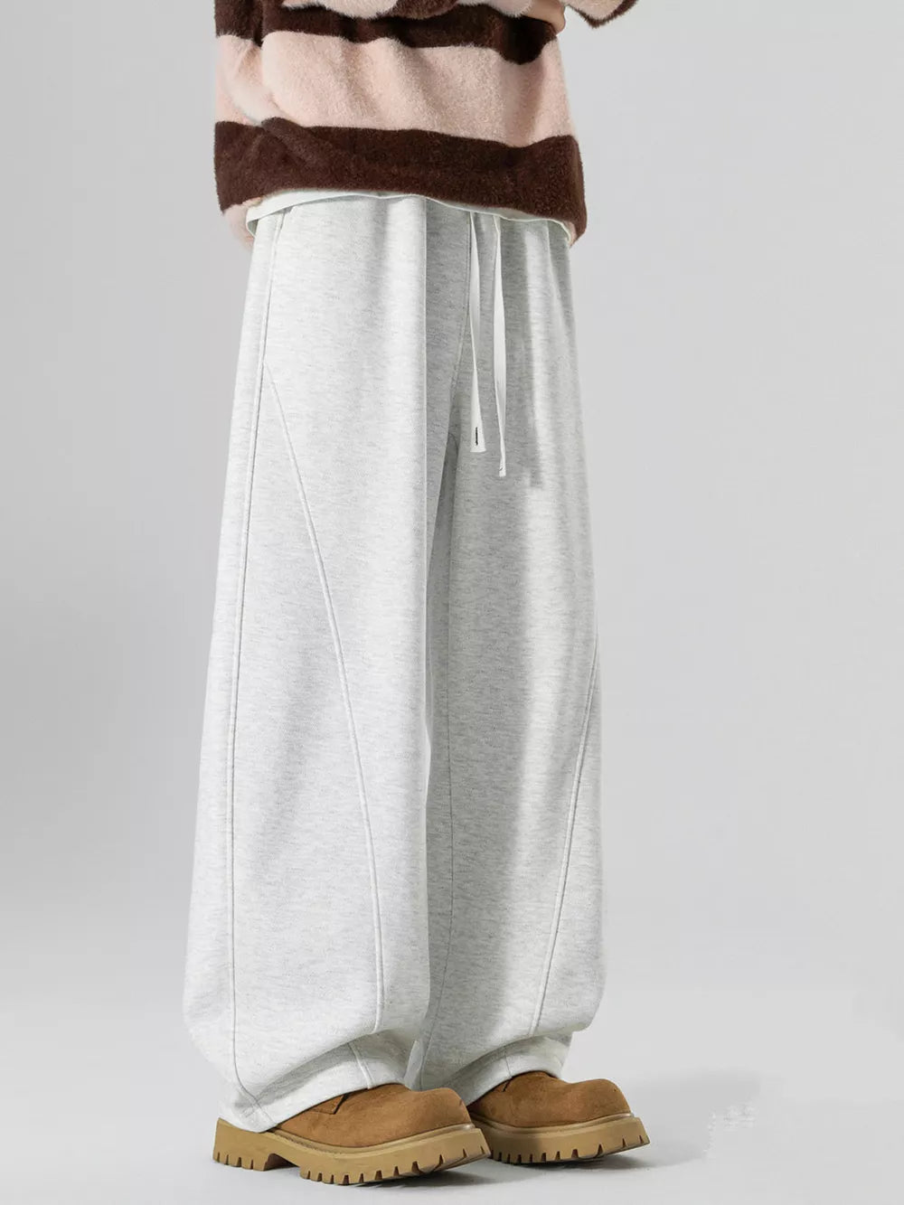 Light gray wide-leg sweatpants with drawstring and curved seam details.