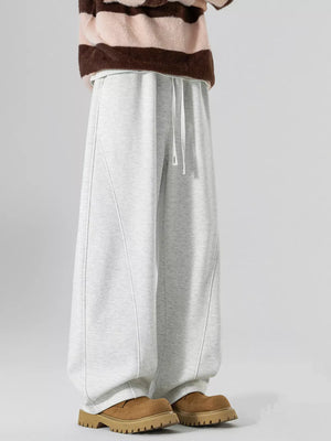 Light gray wide-leg sweatpants with drawstring and curved seam details.