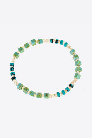 Turquoise cube and crystal beaded bracelet with teal and light green accents.