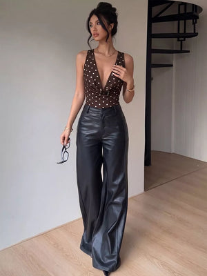 Brown polka dot cowl neck bodysuit with deep V-neck and sleeveless cut.