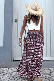 Maxi skirt with geometric print, smocked waist, and tiered hem in plum and white.