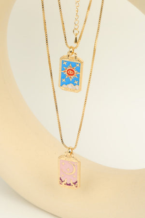 Celestial tarot pendant necklace set with sun and moon charms in gold tone copper.