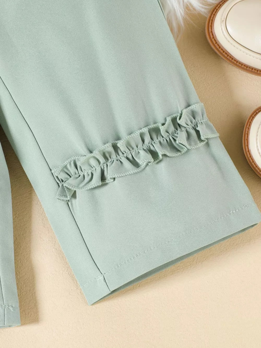 Green toddler set with floral ruffle trim detail on sleeves.