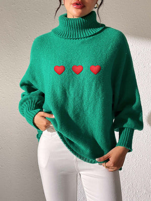 Green turtleneck sweater with balloon sleeves and three red heart appliqués.
