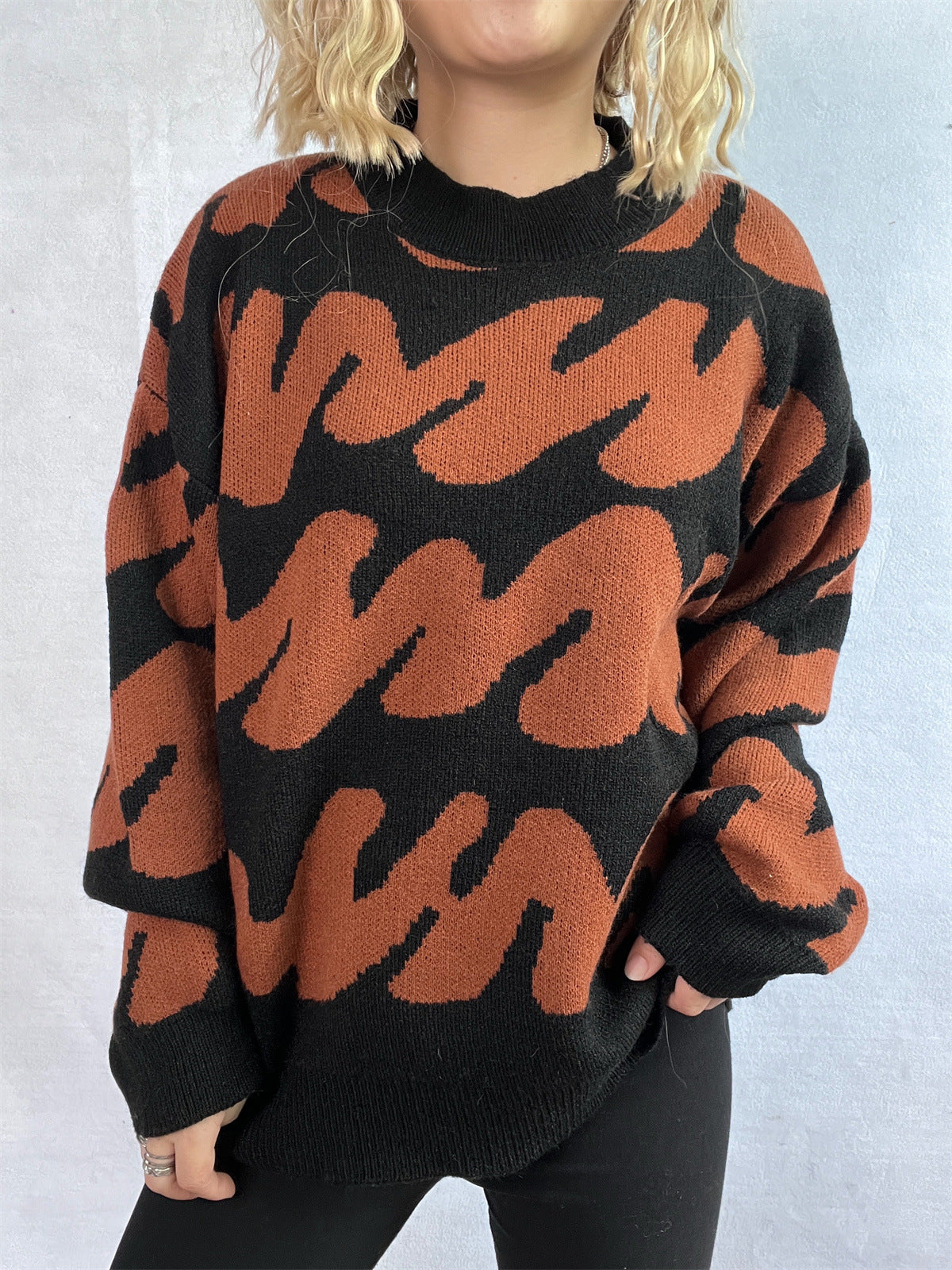 Graphic wave knit sweater in black and camel with mock neck and long sleeves.
