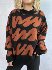 Graphic wave knit sweater in black and camel with mock neck and long sleeves.
