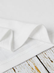 White t-shirt detail showing hem stitching and soft fabric texture.