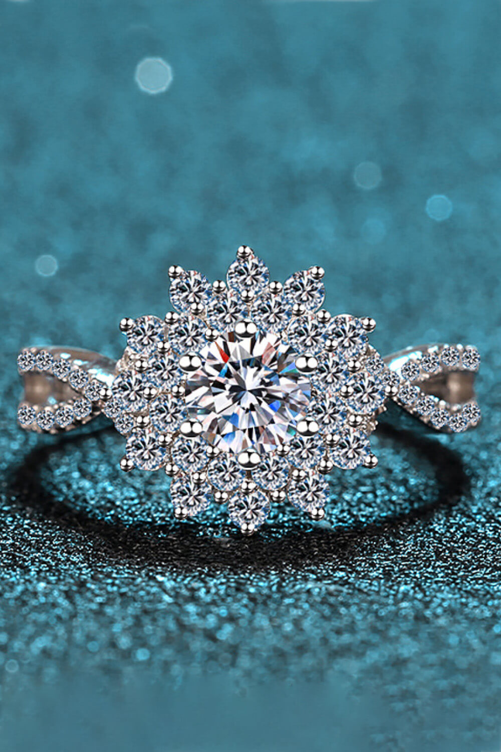 Silver ring with a large round center moissanite surrounded by a halo of smaller stones in a floral design.
