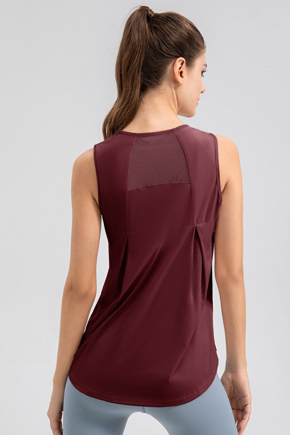 Burgundy mesh panel performance tank top with back pleats.