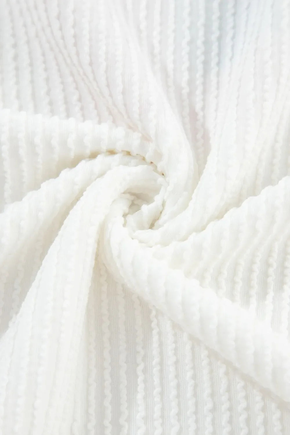 White ribbed knit sweatshirt fabric detail with vertical textured pattern.