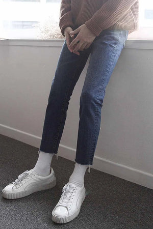 Slim-fit jeans in medium wash denim with raw hem detail.