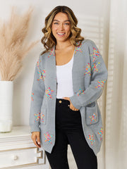 Gray acrylic knit cardigan with colorful starburst pattern and pockets.