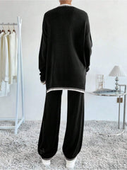 Black knit loungewear set with white striped trim and slit detail on sweater.