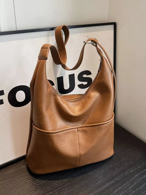 Brown leather hobo shoulder bag with adjustable strap and front pocket detail