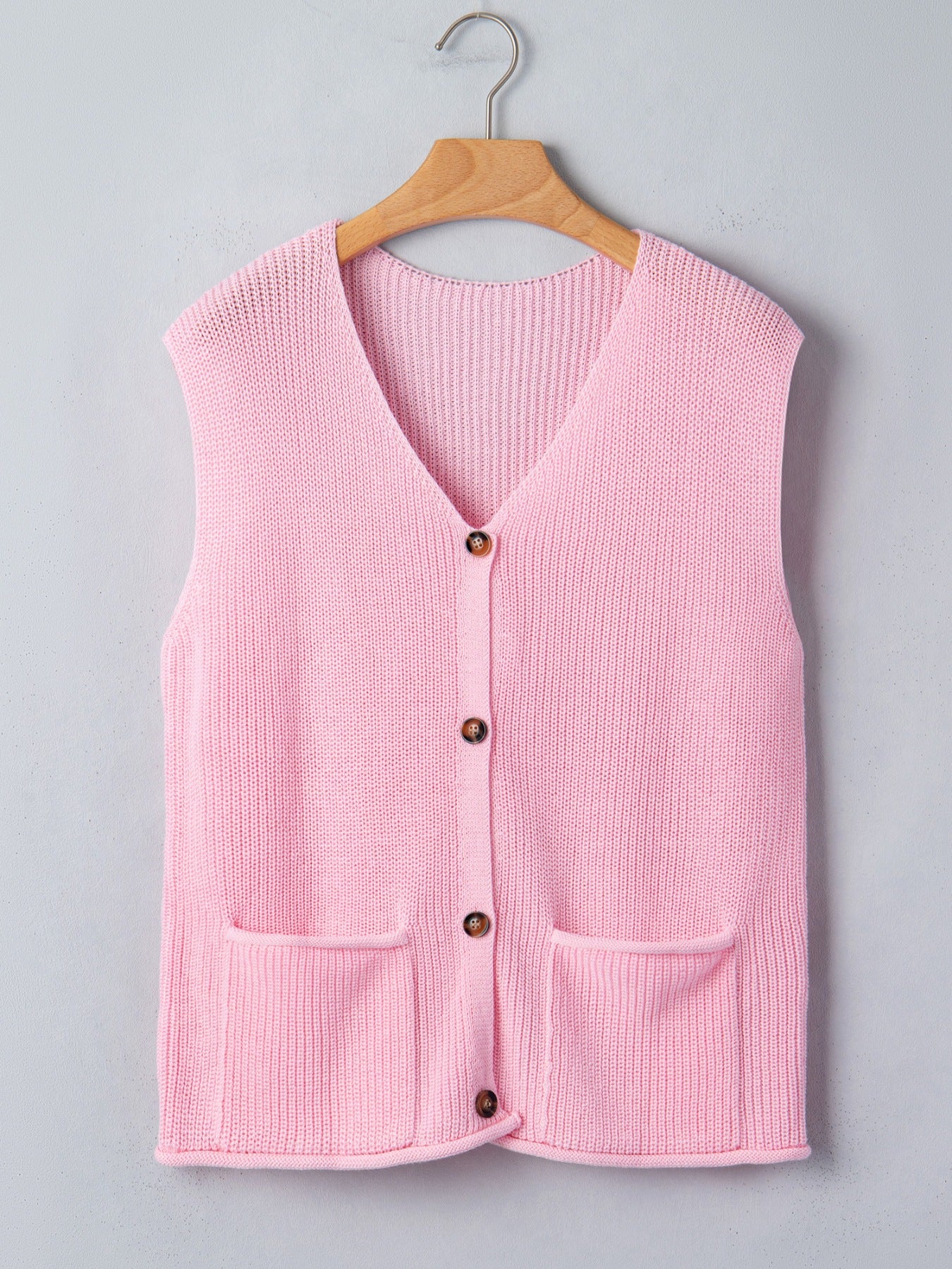 Pink acrylic button front V neck sweater vest with two front pockets.