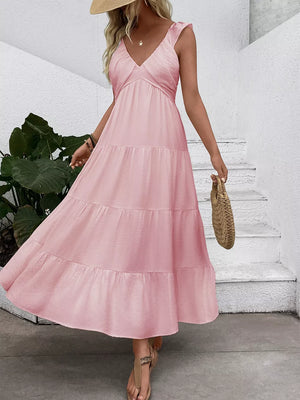 Blush pink tiered maxi dress with flutter sleeves and V-neck, flowing skirt.
