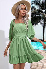 Light Green mini dress with square neck, puff sleeves, tiered hem, and tie waist.